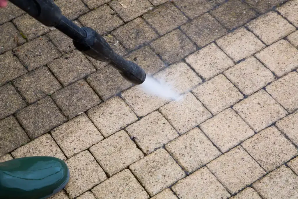 Dark oil stain on a concrete driveway with a stiff brush and degreaser showing how to remove oil stains from concrete
