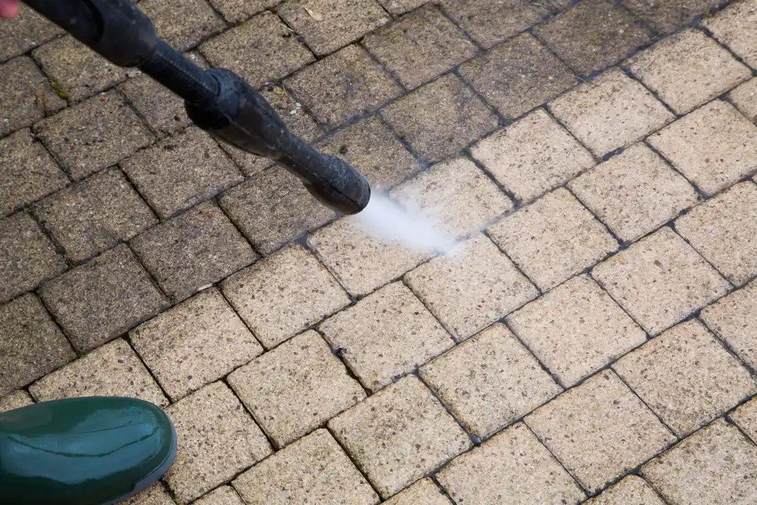 Dark oil stain on a concrete driveway with a stiff brush and degreaser showing how to remove oil stains from concrete