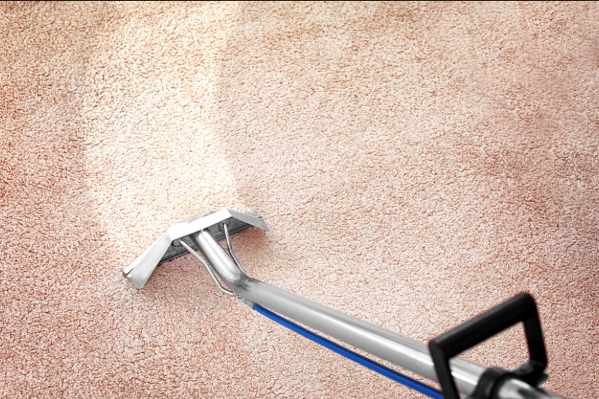 Technician washing a wool area rug on a cleaning facility wash floor to show what affects rug cleaning cost